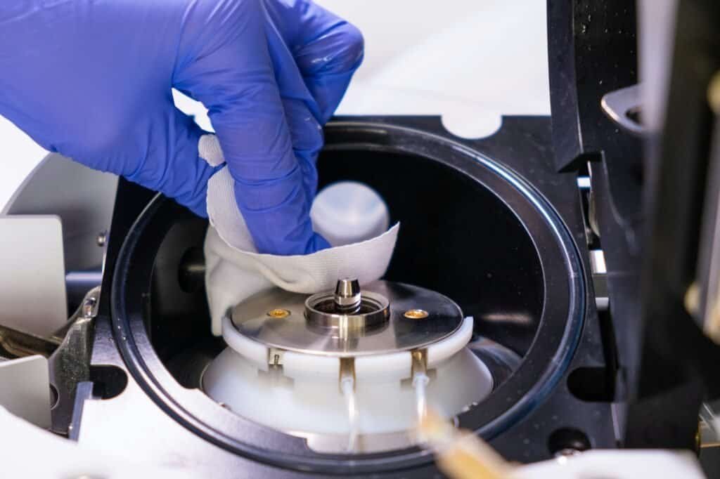 Cleaning of ion source of mass spectrometer by laboratory worker in rubber gloves. LC MS, liquid