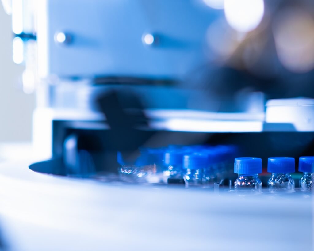 HPLC glass vials with blue caps in the auto sampler. Chemical analysis of plants and human samples.