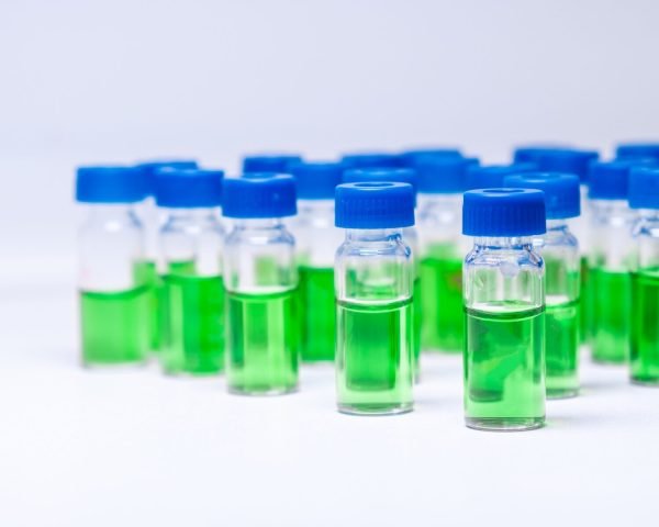 HPLC vials with green sample of plant extracts. Developing of drugs based on natural products